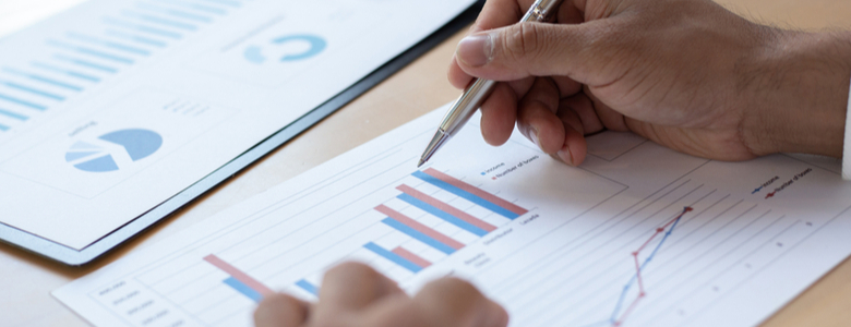 A person reviewing graph data on paper.