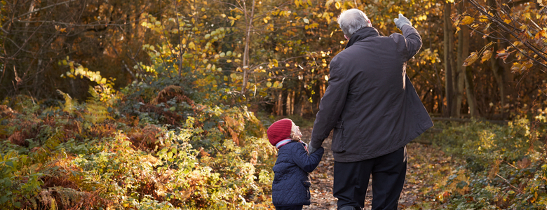A grandfather and granddaughter on an autumn walk.