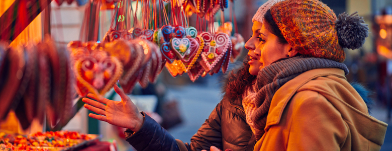 Two women looking at a Christmas market stall.