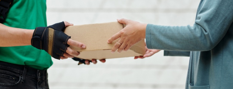 A delivery man handing a customer a parcel.