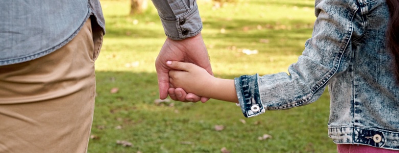 Parent and child holding hands.