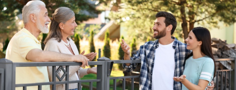 A young couple talking to their older neighbours.