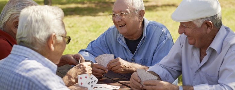 A group of friends playing cards outdoors.
