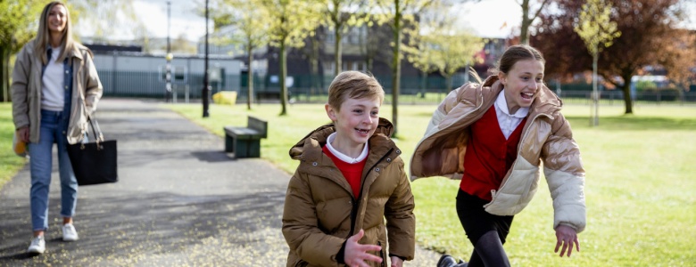 A mum and two children walking home from school.