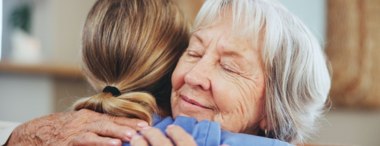 A senior woman hugging a caregiver.