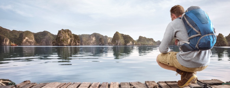 Traveller crouching on a jetty.
