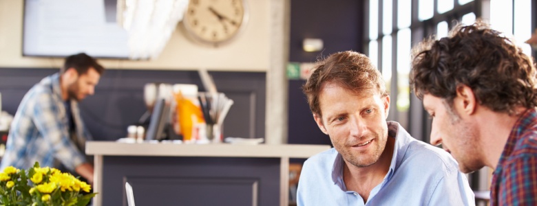 Two men talking in a café.