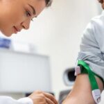 A doctor preparing to draw blood from a man.