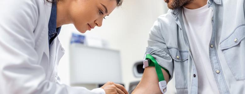 A doctor preparing to draw blood from a man.
