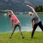 Couple doing tai chi by a lake