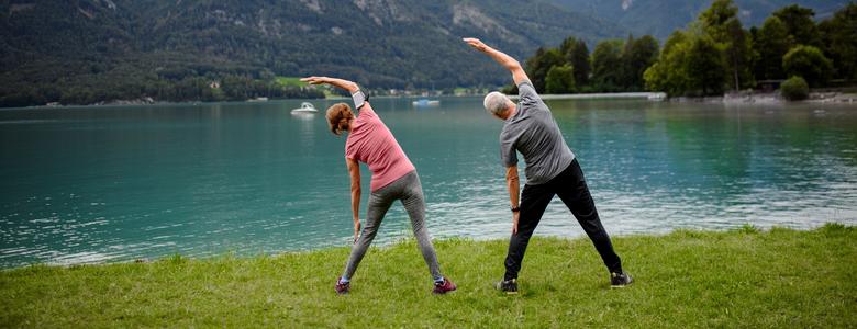 Couple doing tai chi by a lake
