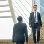 Three office workers crossing on some steps.