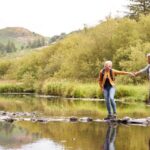 A couple walking across stepping stones.