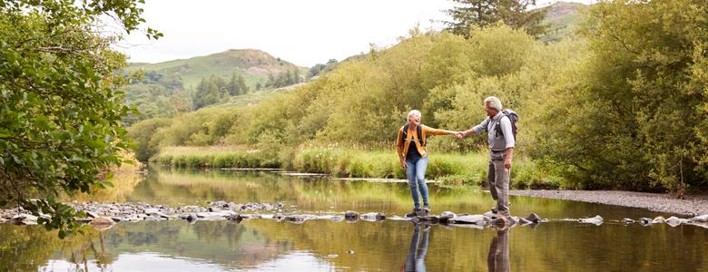 A couple walking across stepping stones.