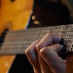 A close-up of someone playing a guitar.
