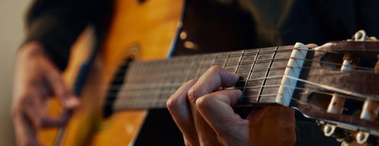 A close-up of someone playing a guitar.