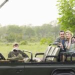 A group of tourists on safari taking a photo of a leopard.