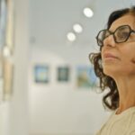A woman looking at a painting in an art gallery.