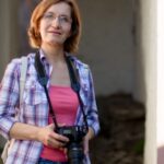 Woman on an urban street holding a camera