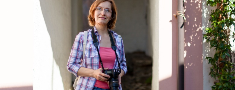 Woman on an urban street holding a camera