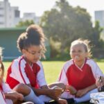 A woman coaching a girl’s football team.
