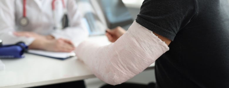 A man with a broken arm speaking with a doctor.