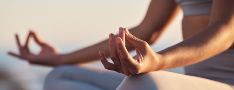 A woman sitting in the lotus position mediating.