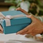 A person gifting a wrapped birthday present.