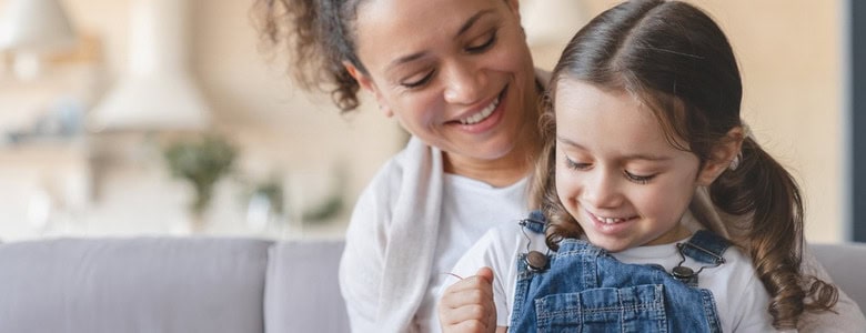 A mother and daughter unwrapping a gift.
