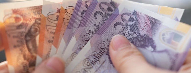 A person holding UK bank notes.